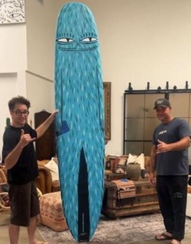 The full KA Log surfboard, hand-painted by Evan Rossell, standing indoors